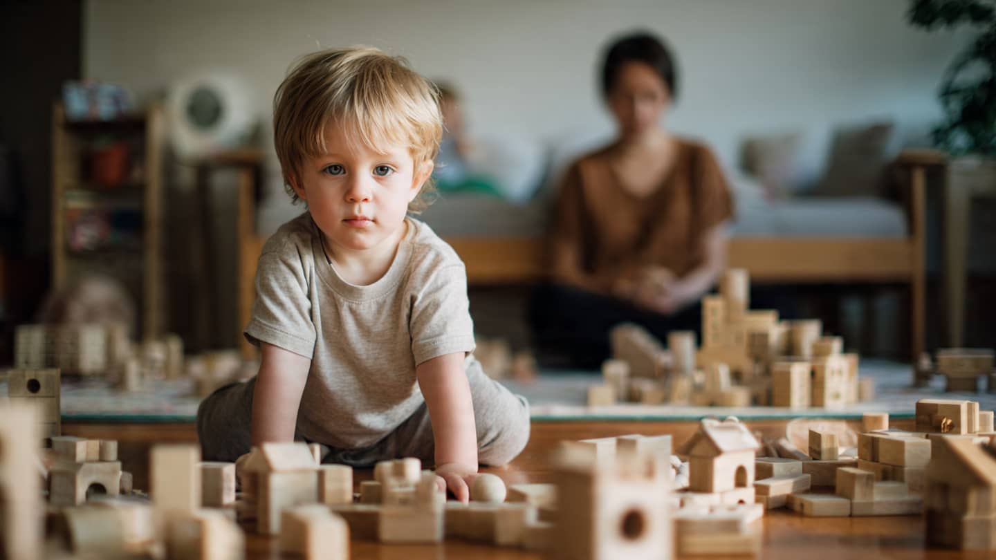 Parent accompagnant un enfant de 2 ans dans le jeu sans intervenir