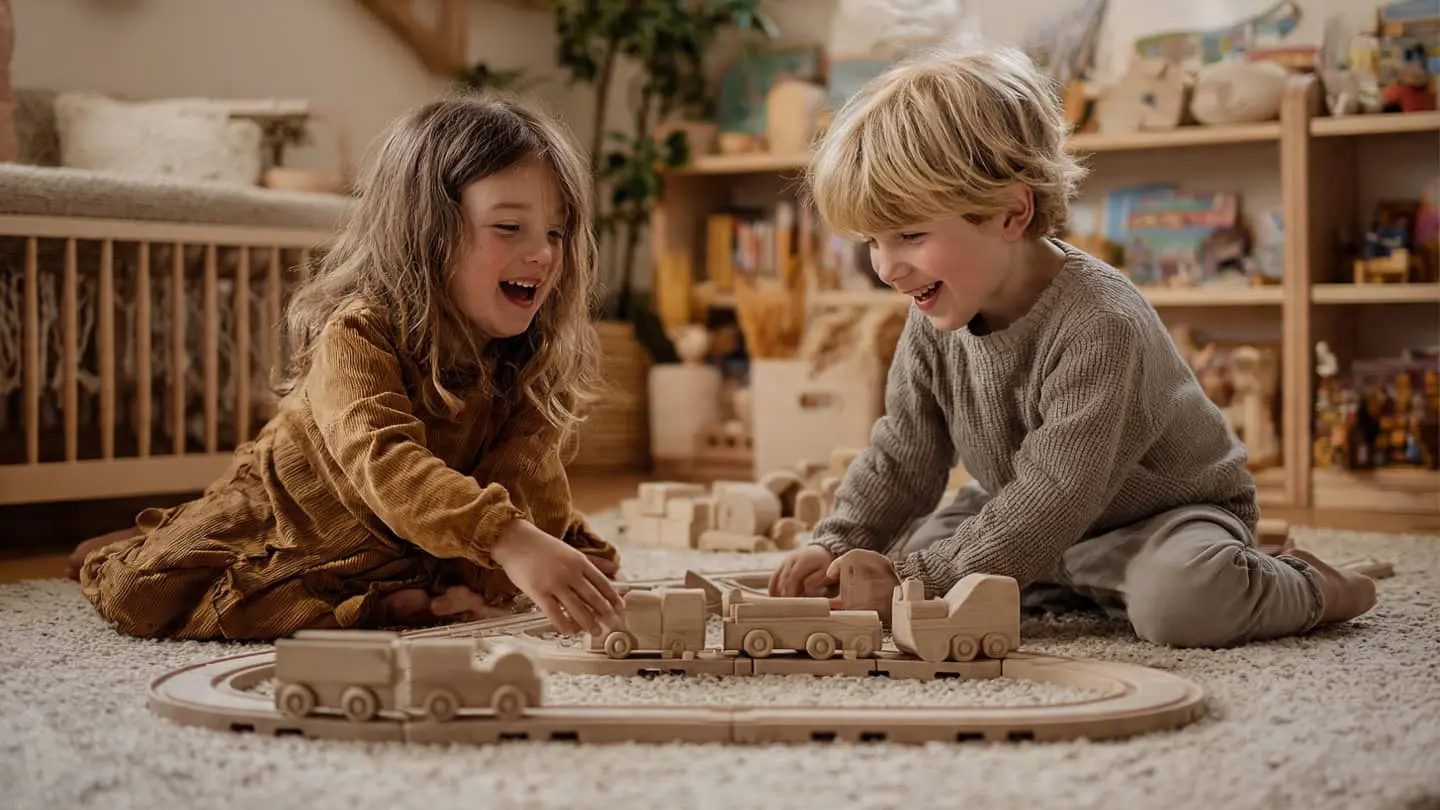 enfants jouent ensemble train en bois tapis salon partage