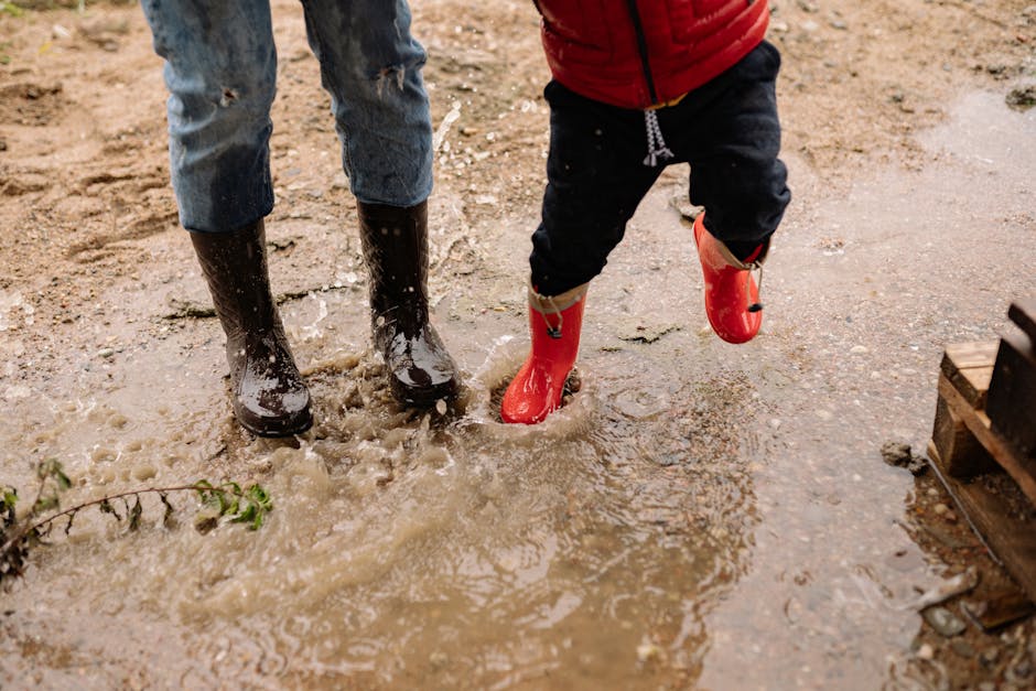 Enfants jouant sous la pluie avec des bottes colorées