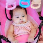 Bébé dans un transat jouant avec ses premiers jouets