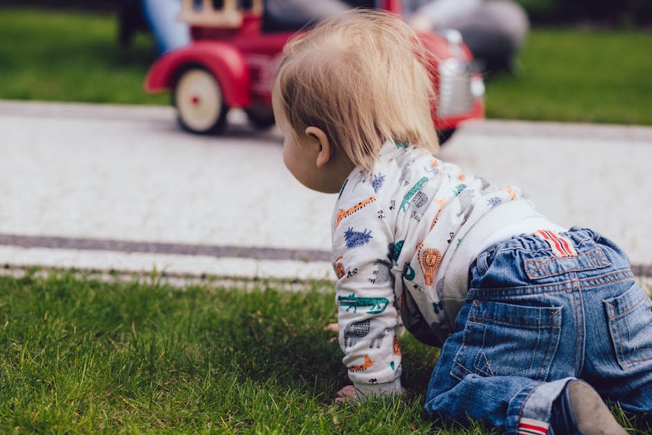 Bébé qui se déplace vers un jouet sur l’herbe