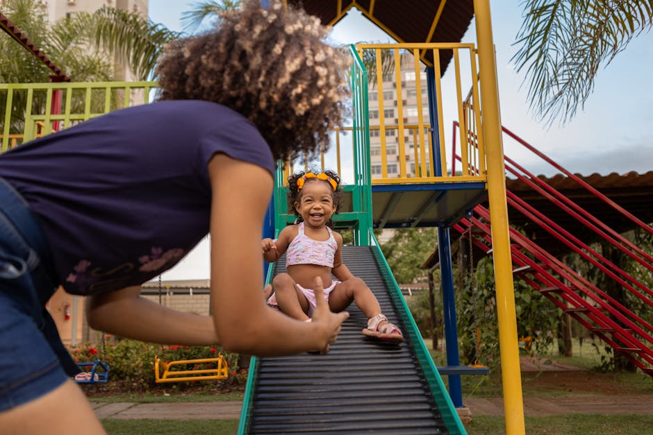 Maman et enfant sur un toboggan au parc