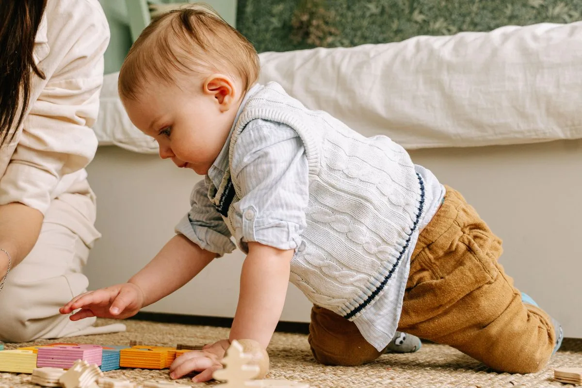 Bébé en éveil sensoriel Montessori explorant des blocs colorés