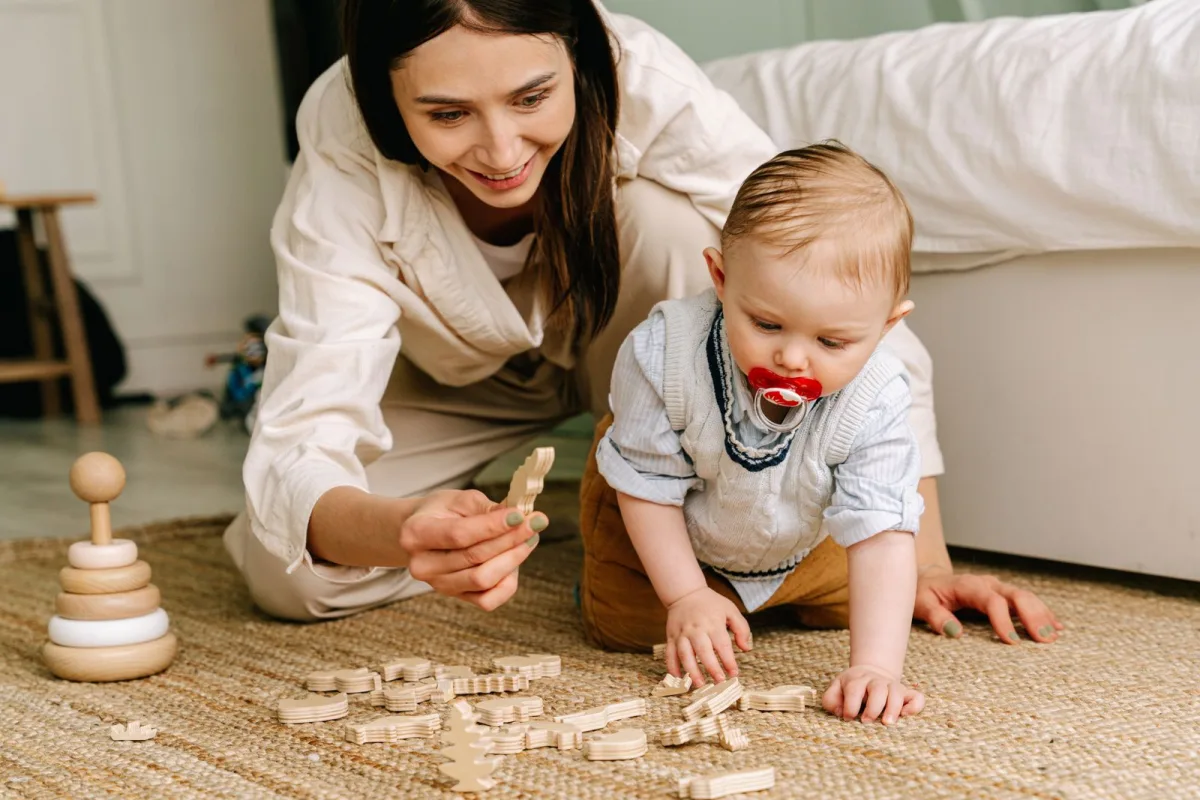 Bébé 1 an jouant avec des jouets en bois sur le sol