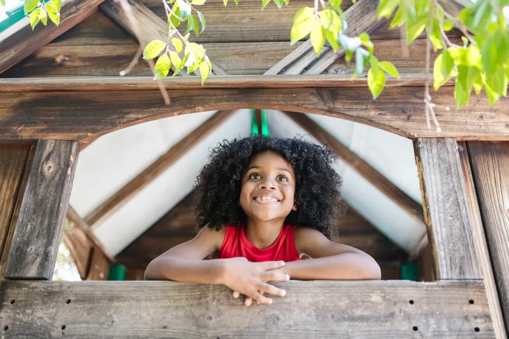 enfant jouant dans cabane bois jardin extérieur été