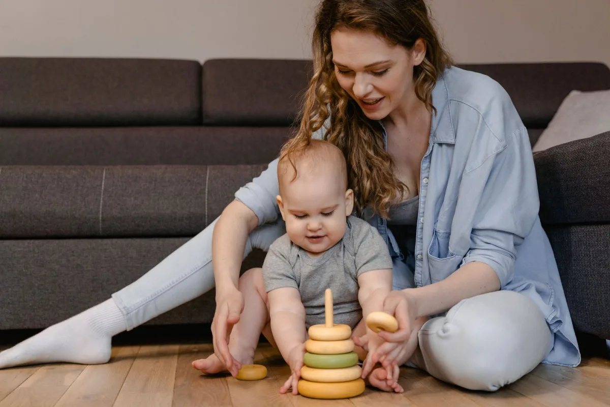 Mère et bébé jouant ensemble avec des jouets colorés en bois
