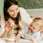 Idée cadeau bébé 1 an - mère et bébé jouant avec des jouets en bois