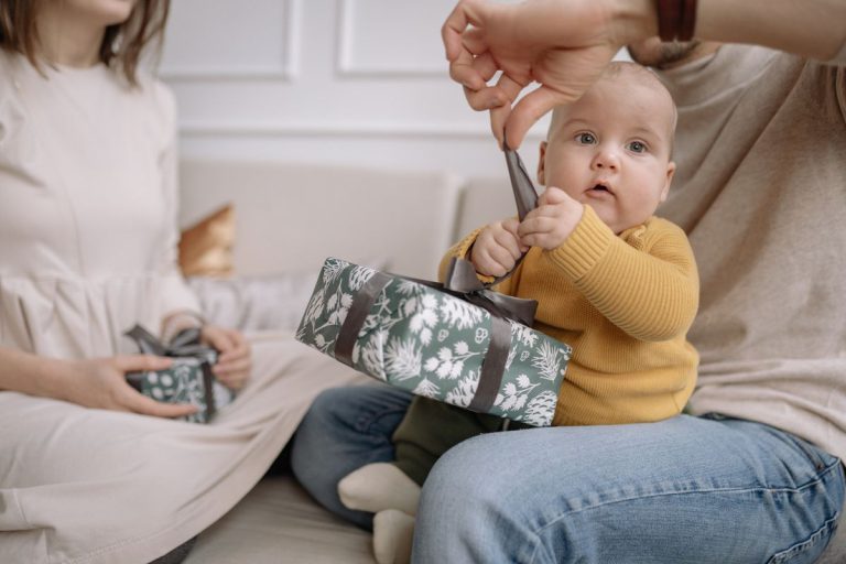 Cadeau naissance garçon : bébé avec parents qui ouvrent un coffret