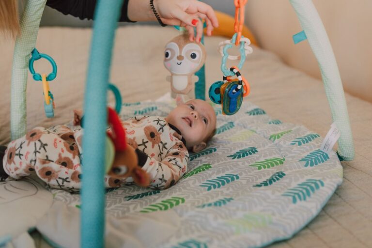Bébé de 6 mois jouant avec un tapis déveil coloré et des jouets sensoriels