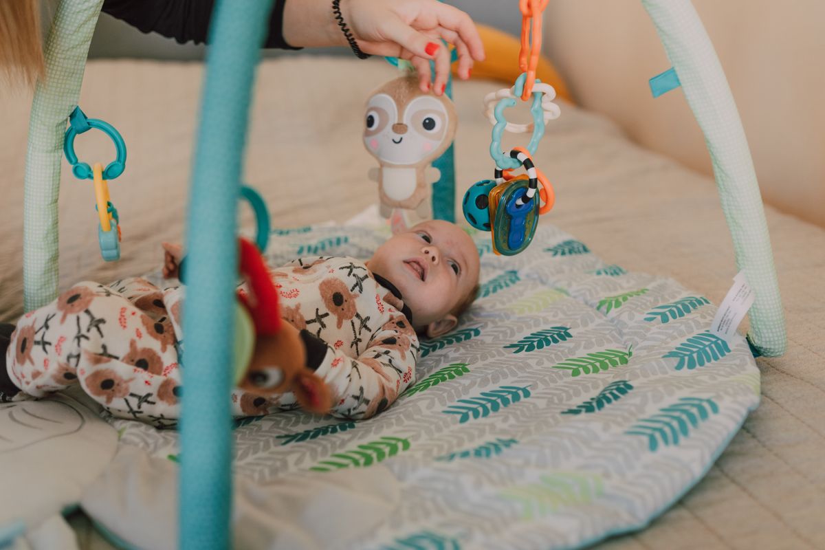 Bébé de 6 mois jouant avec un tapis d'éveil coloré et des jouets sensoriels