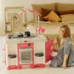Petite fille ouvrant le four de sa cuisine enfant en plastique