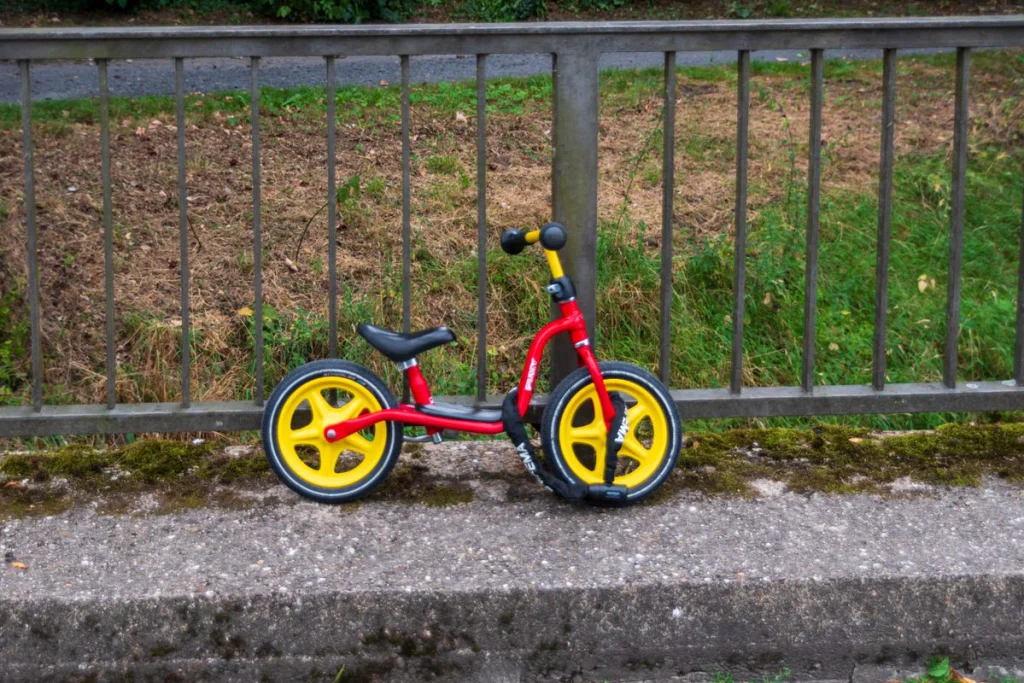 Draisienne enfant sans pédales vue de profil, selle basse et roues de 12 pouces
