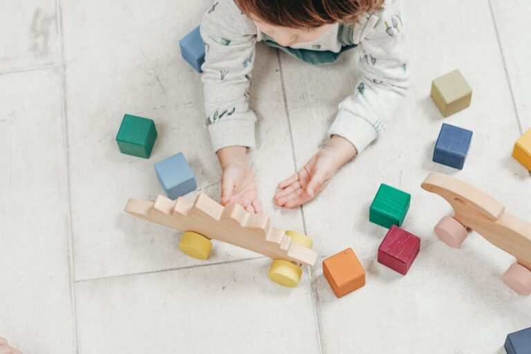 Bébé de 12 mois jouant avec des jouets en bois colorés sur un tapis