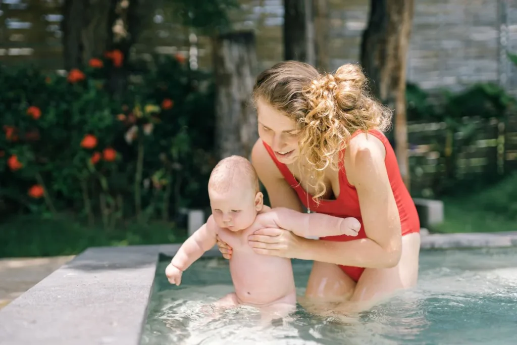 Tout-petit accompagné par un adulte dans une eau peu profonde