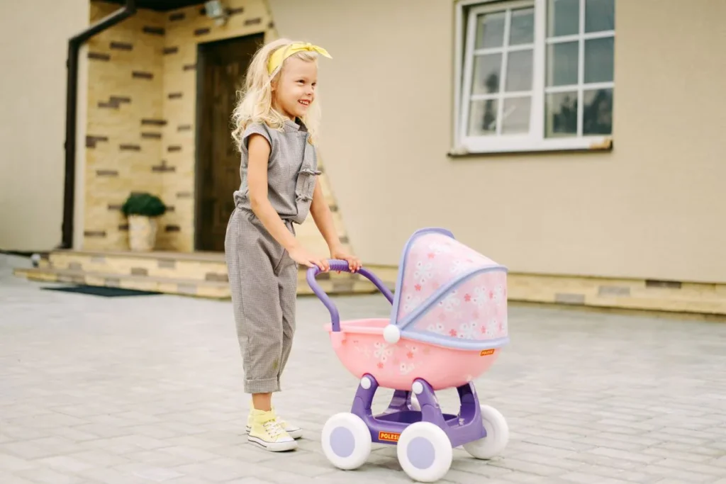 Enfant poussant une poussette pour poupée, poignée à sa hauteur