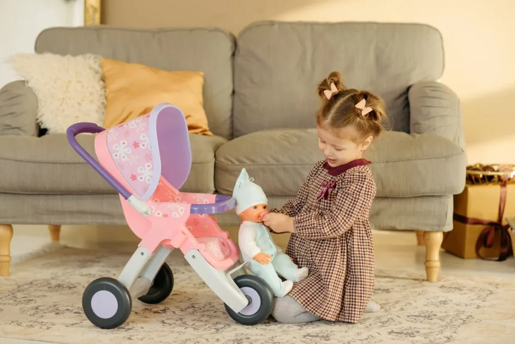 Enfant installant son poupon dans une poussette pour poupée