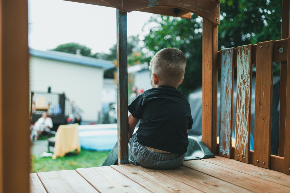 Enfant grimpant sur un toboggan extérieur dans le jardin