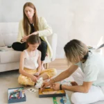 Famille qui joue a un jeu de societe avec un enfant de 6 ans dans le salon