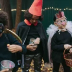 Trois enfants en déguisement d'Halloween ramassent des bonbons dans la rue le soir