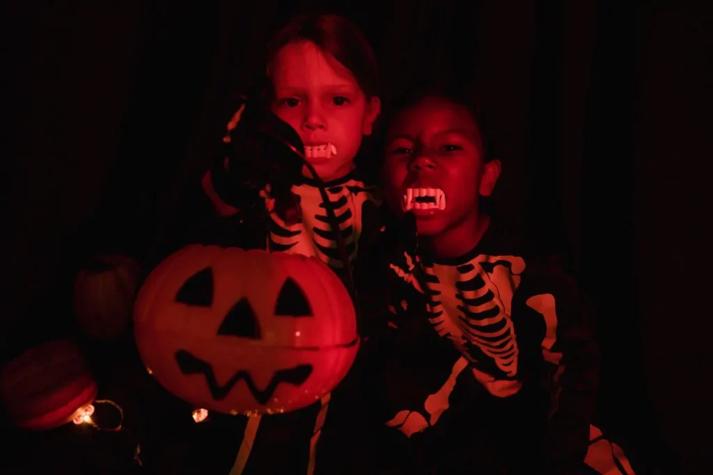 Deux enfants en costume de squelette éclairés dans le noir pendant Halloween