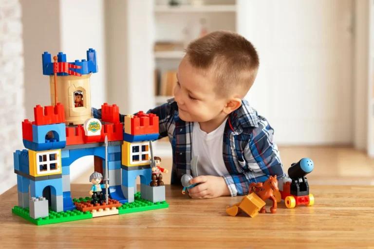 Garçon qui joue avec un château en briques et ses figurines, idée de cadeau à 4 ans