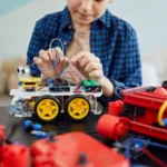 Garçon qui assemble une voiture robot à construire, idée de cadeau pour un enfant de 7 ans